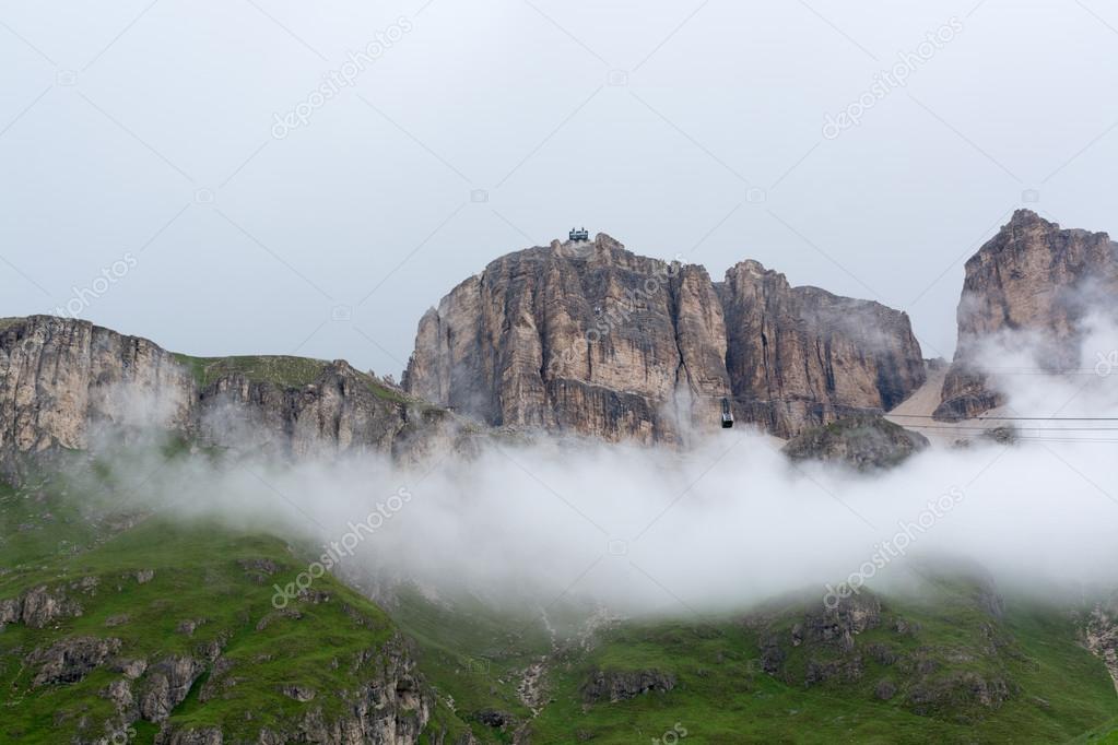 Sass Pordoi massif hidden in clouds with cable car leading on to