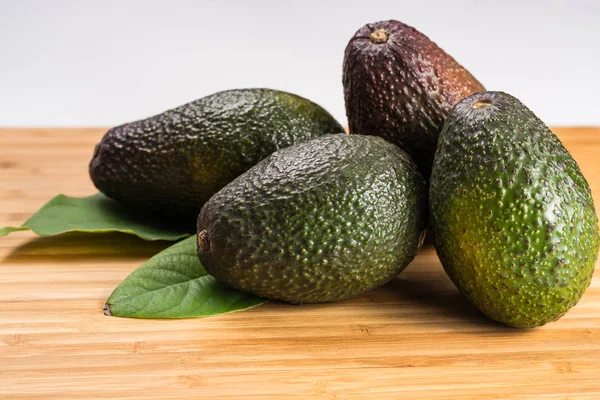Groene verse avocado met bladeren — Stockfoto