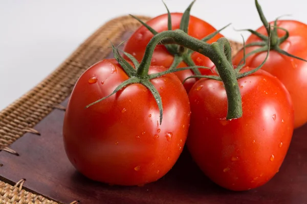 Tomates vermelhos frescos em um ramo. Tomates com gotas de água . — Fotografia de Stock