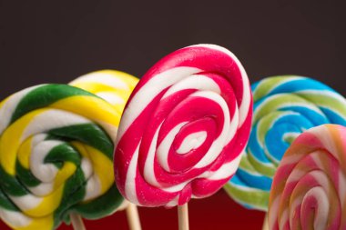 Multicolored sweet candy canes and twirls on wooden sticks clipart