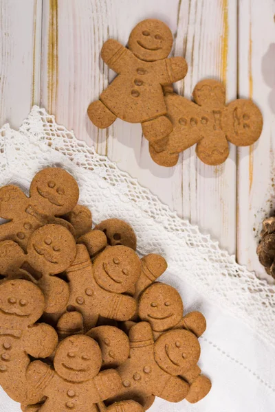 Many Christmas smiling  gingerbread men on white lace — Stock Photo, Image