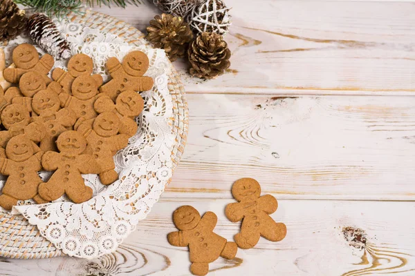 Many Christmas smiling  gingerbread men on white lace