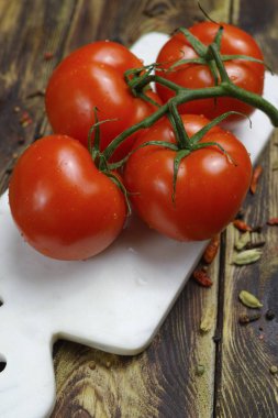 Beyaz mermer tahta dalında ham organik kırmızı domates