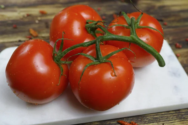 Tomates vermelhos orgânicos crus na videira — Fotografia de Stock