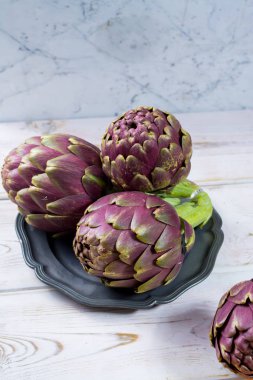 Taze büyük Romanesco enginar yeşil-mor çiçek başları hazır t