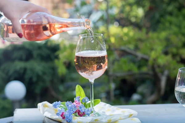 Waiter pouring a glas of cold rose wine, outdoor terrase, sunny