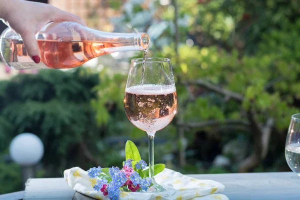 Camarero vertiendo una copa de vino de rosas frías, terrase al aire libre, soleado — Foto de Stock