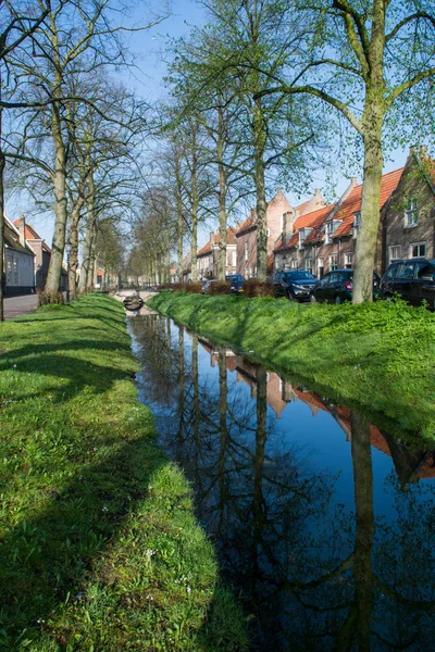 Passeggiata lungo il piccolo canale nel vecchio villaggio olandese, domenica di sole — Foto Stock