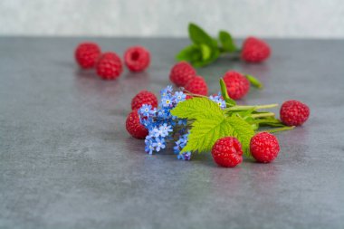Yapraklarda gri arka plan, kopya spac ile tatlı taze ahududu