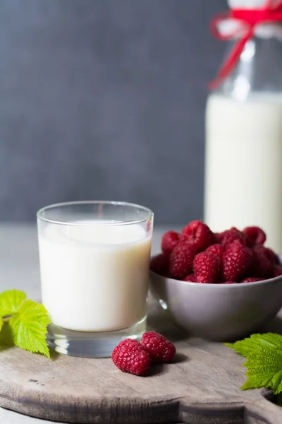 Свіже коров'яче молоко та стиглі органічні червоні малини — стокове фото