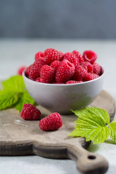 Fresh organic fruit - ripe raspberry with leaves on wood background — Stock Photo, Image