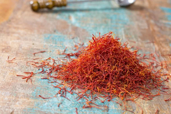 Tempero de açafrão vermelho orgânico seco em fundo de madeira — Fotografia de Stock