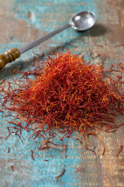 Tempero de açafrão vermelho orgânico seco em fundo de madeira — Fotografia de Stock