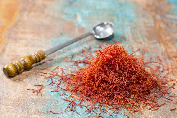 Azafrán rojo orgánico seco Especia sobre fondo de madera —  Fotos de Stock