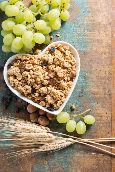 Desayuno saludable de granola muesli con uva, nueces y espigas de trigo — Foto de Stock