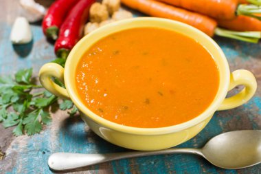 Harissa yapılmış sıcak biber, limon, sarımsak, mavi ahşap masa üzerinde kişniş ile baharatlı havuç çorbası