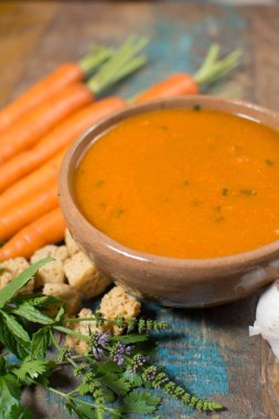 Harissa yapılmış sıcak biber, limon, sarımsak, mavi ahşap masa üzerinde kişniş ile baharatlı havuç çorbası