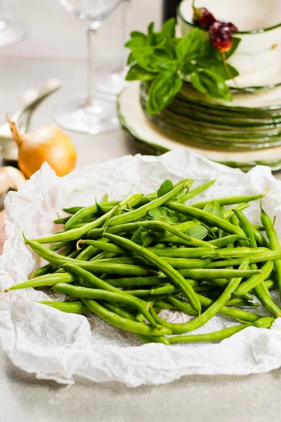 Fresh green snap beans on the plate ready to cook, healthy food