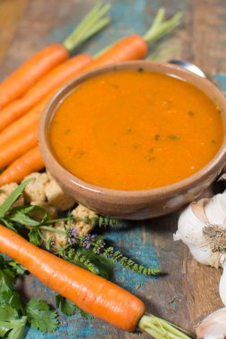 Harissa yapılmış sıcak biber, limon, sarımsak, mavi ahşap masa üzerinde kişniş ile baharatlı havuç çorbası