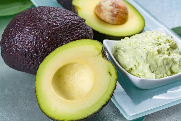 Avocado skin & hair care home spa, ripe avocados and bowl with face mask — Stock Photo, Image