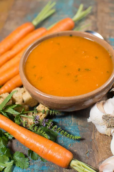 Harissa yapılmış sıcak biber, limon, sarımsak, mavi ahşap masa üzerinde kişniş ile baharatlı havuç çorbası