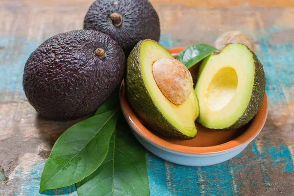 Avocado Fresco Maturo Con Foglie Tavolo Legno Blu Concetto Cibo — Foto Stock