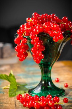 Masanın üzerine taze olgun kırmızı kuş üzümü çilek