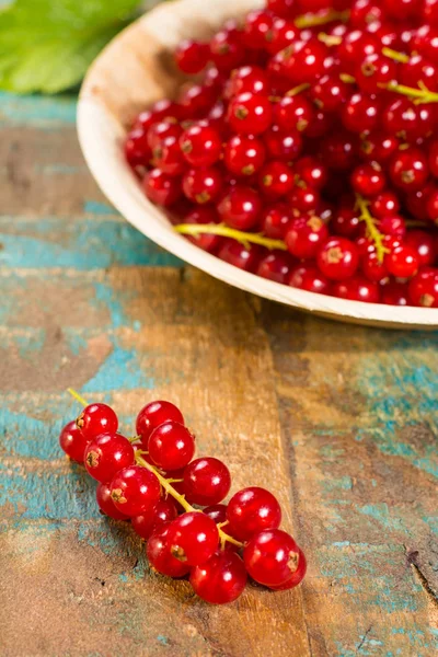 Masanın üzerine taze olgun kırmızı kuş üzümü çilek