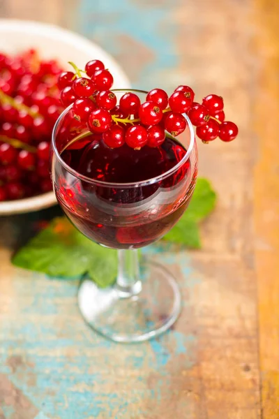 Taze olgun kırmızı kuş üzümü çilek ve likör masada