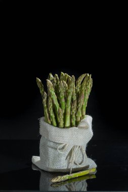 Siyah arka plan üzerine taze çiğ yeşil kuşkonmaz