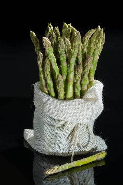 Yansıma, düşük anahtar, karanlık tema siyah zemin üzerine taze çiğ yeşil kuşkonmaz.