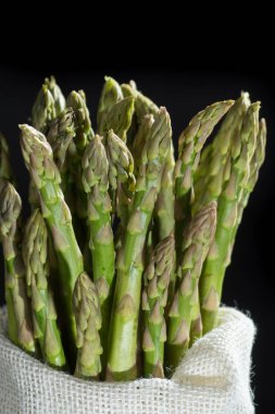 Siyah arka plan üzerine taze çiğ yeşil kuşkonmaz