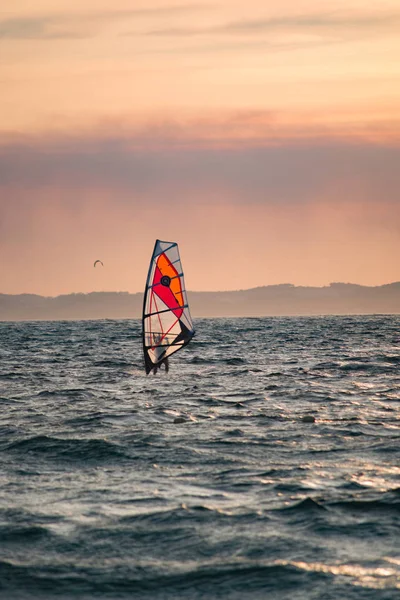 Puesta de sol sobre el mar o el océano y deporte de estilo libre extremo windsur — Foto de Stock