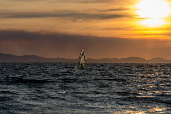 Sunset over the sea or ocean and extreme freestyle sport windsurfing, France, Giens