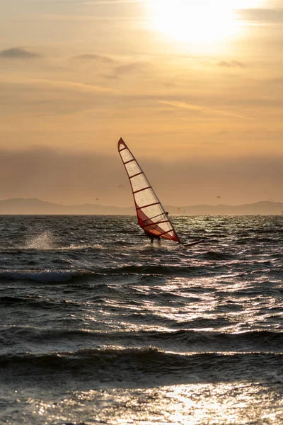 Sunset over the sea or ocean and extreme freestyle sport windsurfing, France, Giens