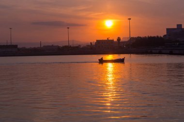 Batan yaz güneşinin ışınlarında balıkçı tekneleri ve lüks yatlar için güzel bir liman. Yatlar için limanda gün batımı. Yat kulübü