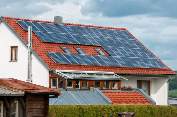 Casa com painéis solares no telhado - sistema de energia regenerativa geração de eletricidade — Fotografia de Stock