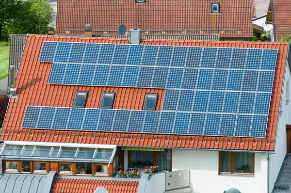 Casa com painéis solares no telhado - sistema de energia regenerativa geração de eletricidade — Fotografia de Stock