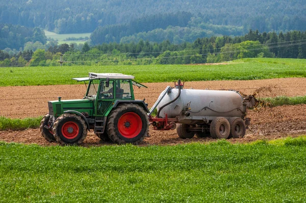 Trattore con campo fertilizzante rimorchio con concime naturale — Foto Stock