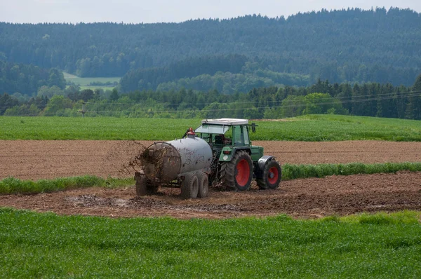 Traktor z przyczepą nawożenia pól z naturalnego nawozu — Zdjęcie stockowe