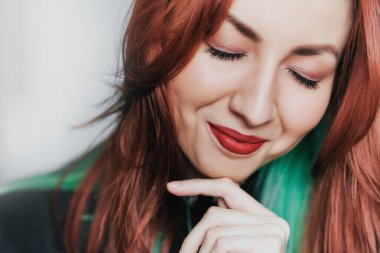 Kızıl dudaklı ve kızıl saçlı genç bir kızın portresi.