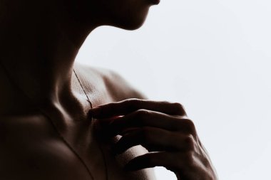 Beyaz bir arka planda güzel bir köprücük kemiği olan koyu renk bir kızın silüeti.