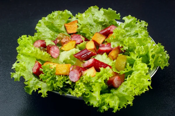 Salad.Chorizo sosis, selada, acar mentimun goreng kentang dengan mayonnaise.Dark latar belakang — Stok Foto