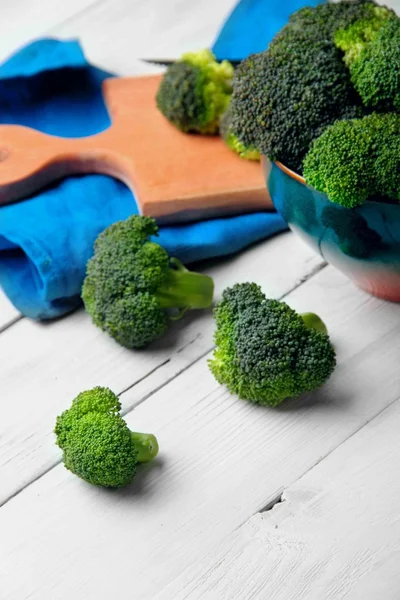 Brokoli tersebar pada papan kayu putih. Space.Selective fokus — Stok Foto