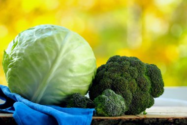 Taze brokoli ve lahana sonbahar bokeh pencere arka plan üzerinde ahşap masa üzerinde. Seçici odak