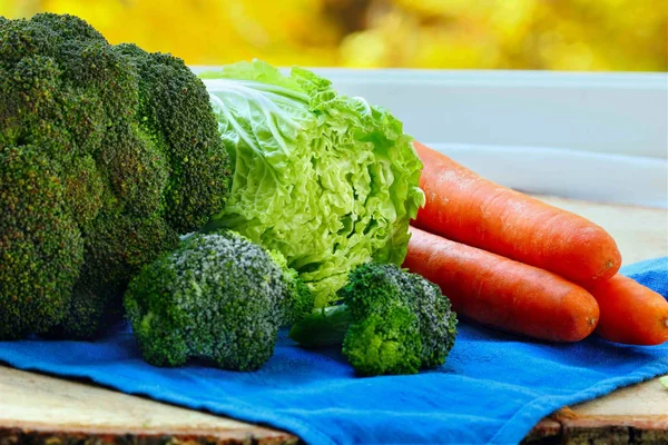 Variasjon av friske grønnsaker, kinakål og brokkoli på trebord. Bokeh i bakgrunnen. Selektivt fokus – stockfoto