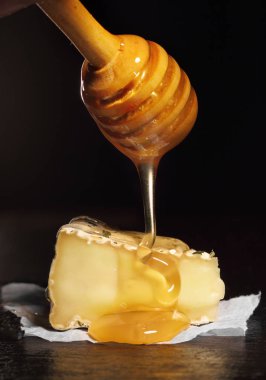 Camembert ile dilim bal bal kaşık gelen dökme ile. Siyah arka plan