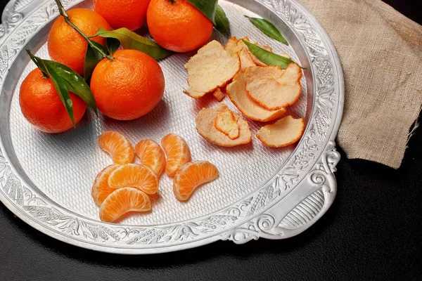 Clementina de tangerina fresca com folhas em bandeja de prata no fundo de pedra escura, topo view.copy espaço. Foco seletivo — Fotografia de Stock