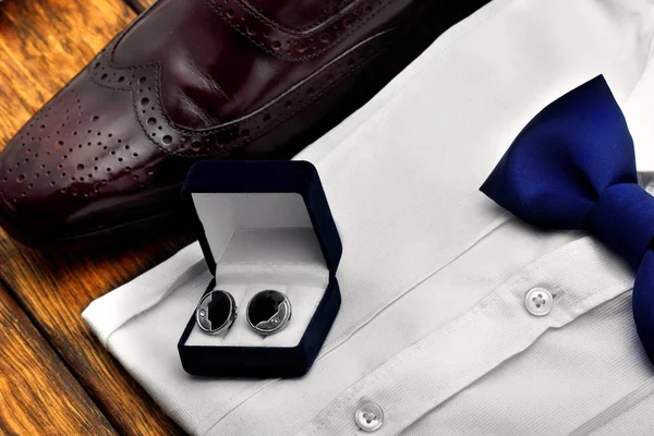 cufflinks on dark blue box, white shirt with tie butterfly and brogues leather shoes .Accessories of men