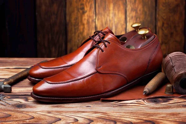 Módní boty derby, které jsou ručně vyráběné a švec nástroje kladivo, šídlo, hřebíky, skien podprocesu. Dřevěné pozadí — Stock fotografie